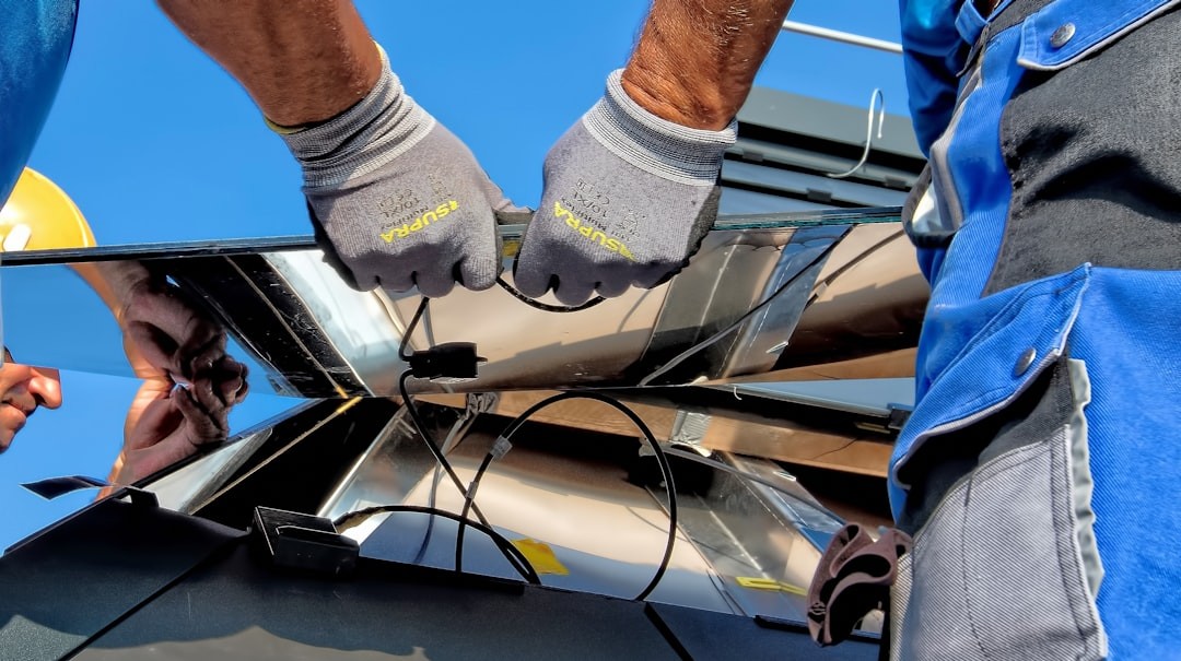 two men carrying a metal sheet